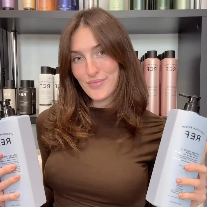 Stylist holding REF haircare products