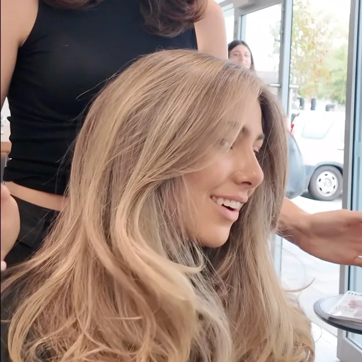 Long softly curled blonde hair inside the salon